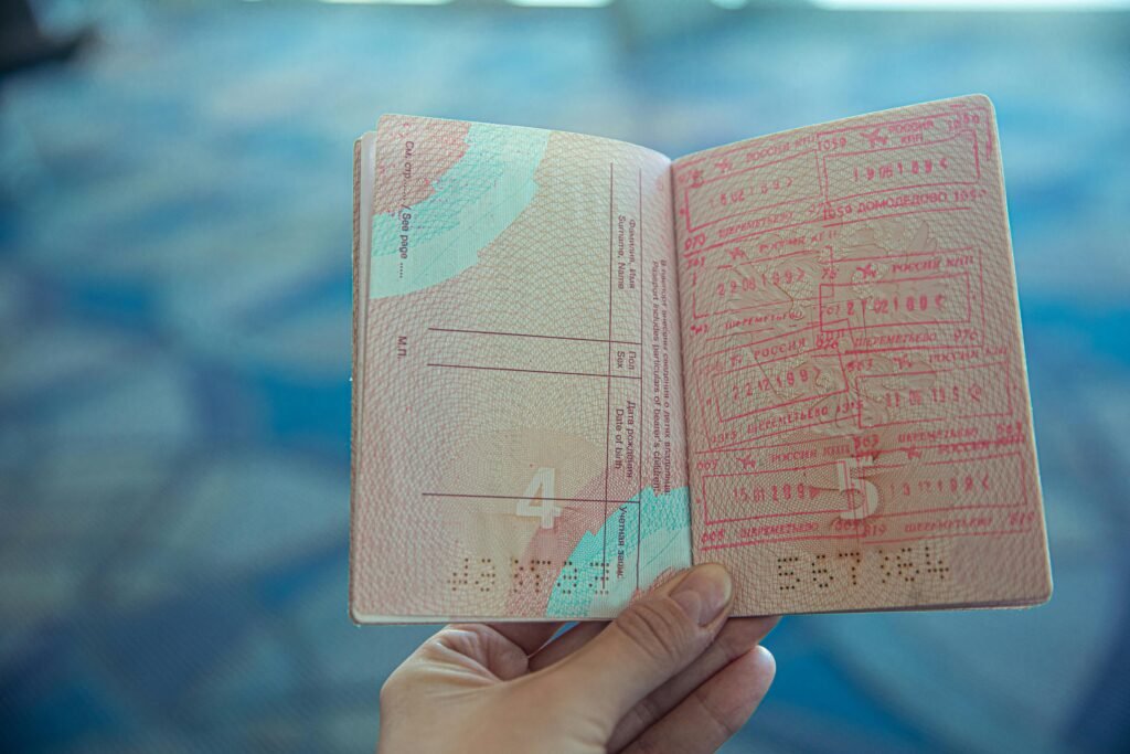 pexels photo 4922356 4922356 Close-up view of an open passport displaying various travel stamps in an airport setting.